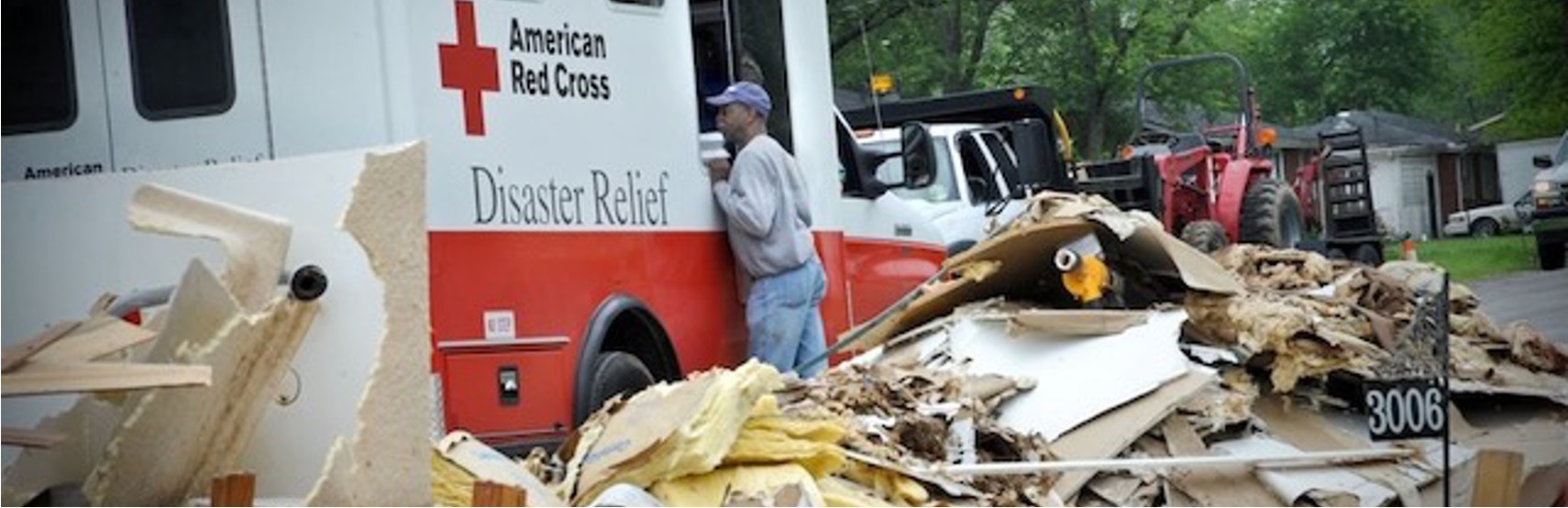 Red Cross disaster relief vehicle at a damaged property
